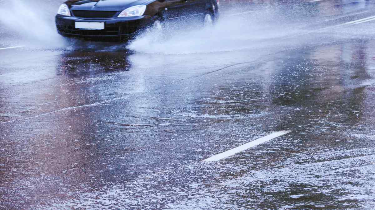 Coche circulando bajo lluvia