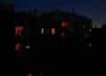 Personas en sus casas durante un apagón nocturno en España, con apenas unas luces encendidas entre la oscuridad