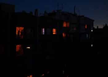 Personas en sus casas durante un apagón nocturno en España, con apenas unas luces encendidas entre la oscuridad