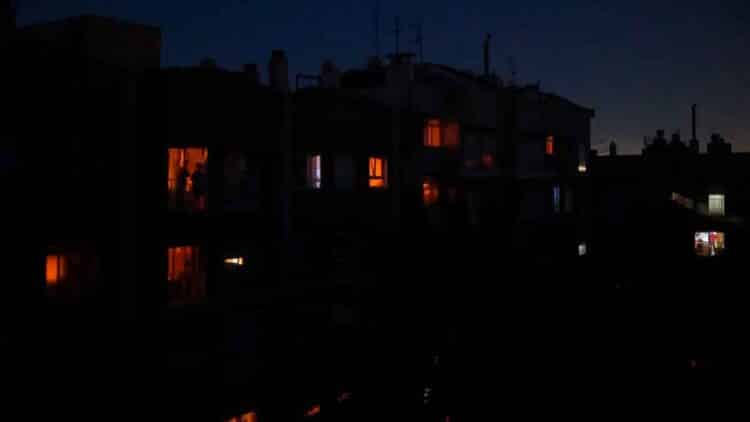 Personas en sus casas durante un apagón nocturno en España, con apenas unas luces encendidas entre la oscuridad