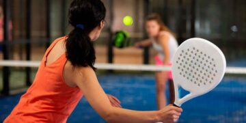 Jugadora de pádel golpea la pelota en pista indoor, ejemplo de deporte no olímpico que opta a las becas 2025 de la Junta de Andalucía