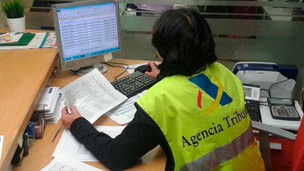 Funcionaria de la Agencia Tributaria revisando declaraciones fiscales en una oficina