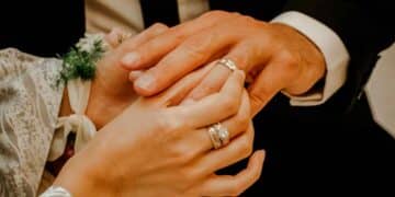 Manos de recién casados mostrando sus anillos de boda, ilustrando la importancia de declarar los regalos ante Hacienda