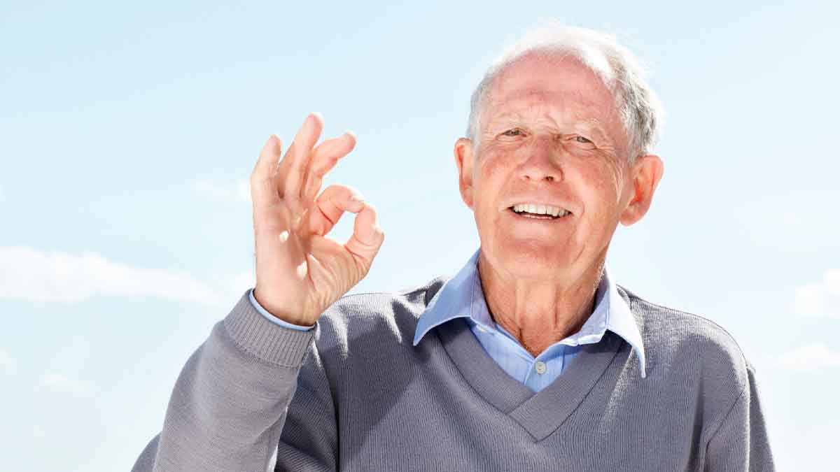 Hombre mayor sonriente hace gesto de OK, símbolo de la deducción fiscal por convivir con mayores de 65 años en la Renta 2025