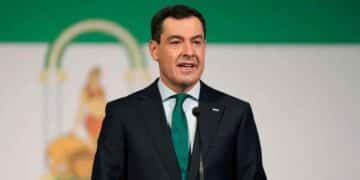 Presidente de la Junta de Andalucía en un podio con la bandera regional de fondo