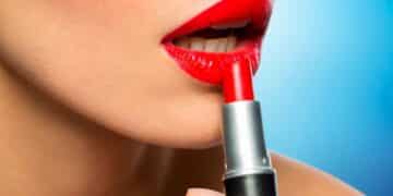 Mujer aplicando pintalabios rojo, reflejando el efecto pintalabios en épocas de recesión económica