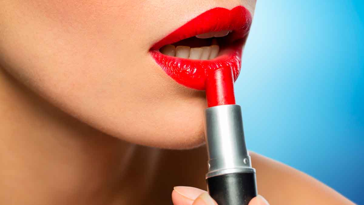 Mujer aplicando pintalabios rojo, reflejando el efecto pintalabios en épocas de recesión económica