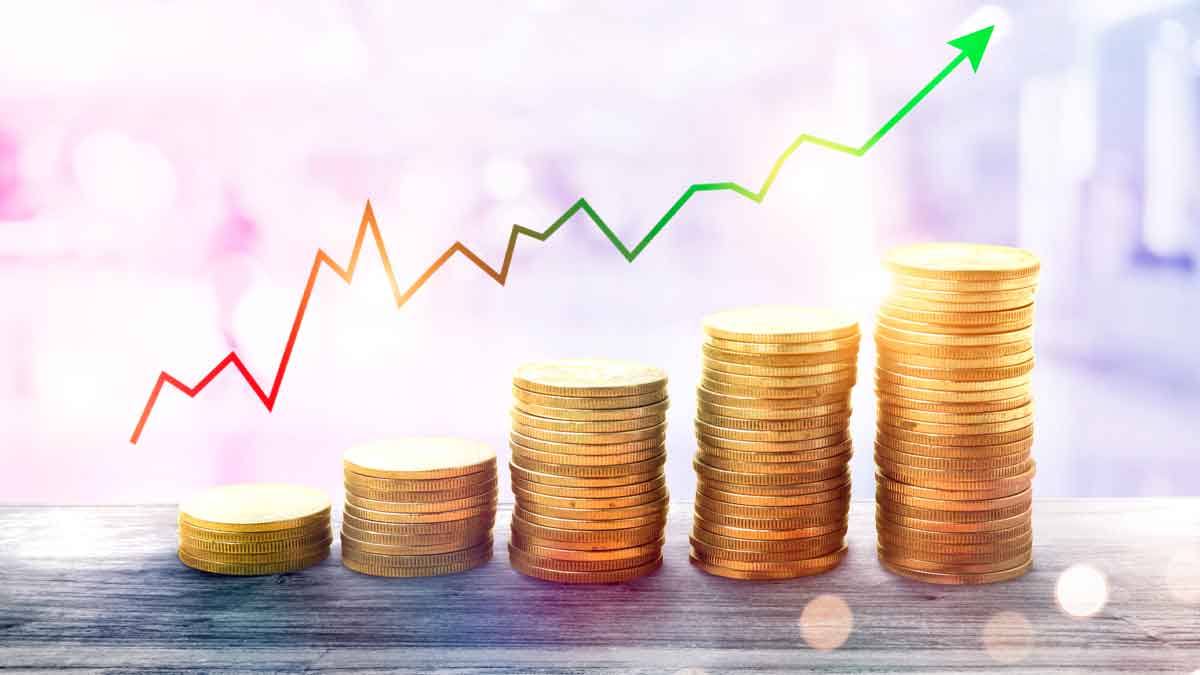 Montones de monedas apiladas con una flecha ascendente, representando inversiones seguras para proteger ahorros en 2025