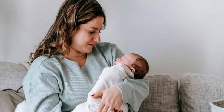 Mujer sosteniendo a un bebé en brazos, representando los nuevos derechos y ayudas de maternidad en Andalucía