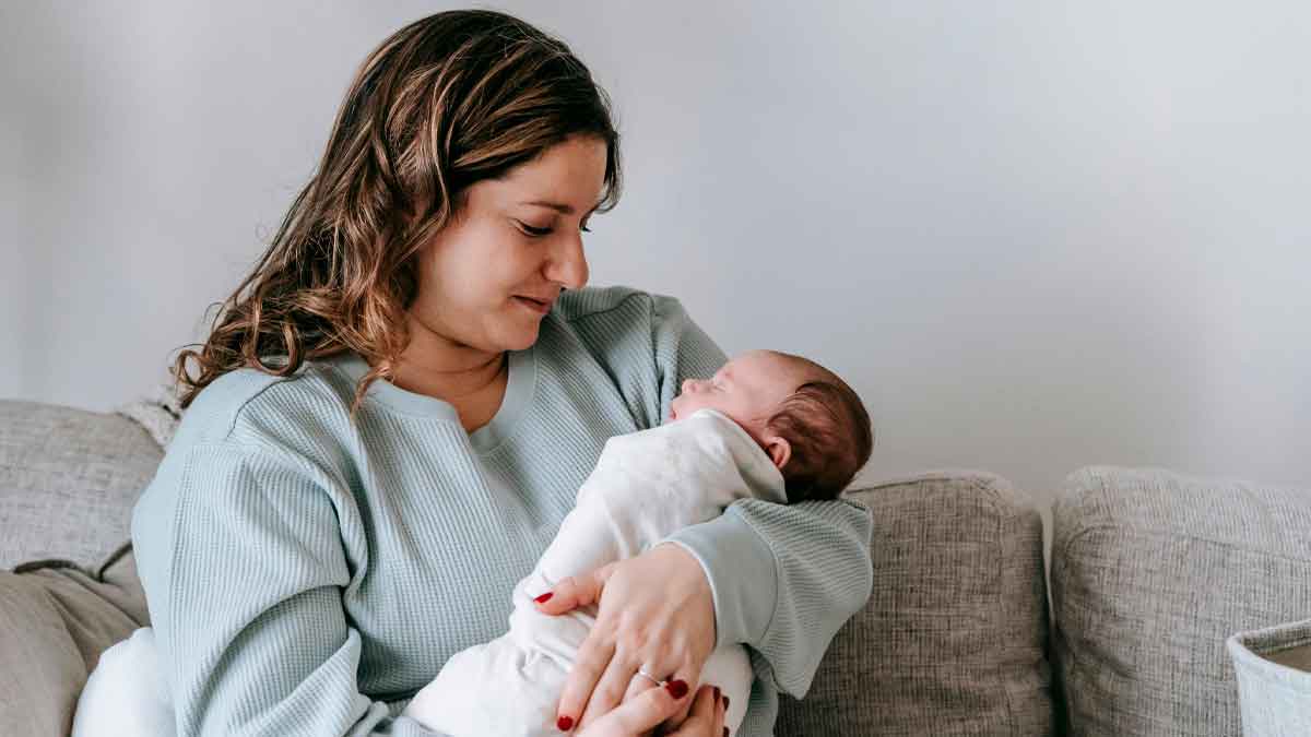 Mujer sosteniendo a un bebé en brazos, representando los nuevos derechos y ayudas de maternidad en Andalucía