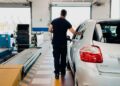 Técnico de ITV revisando un coche diésel antes de realizar la prueba de emisiones