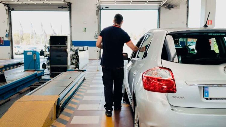 Técnico de ITV revisando un coche diésel antes de realizar la prueba de emisiones