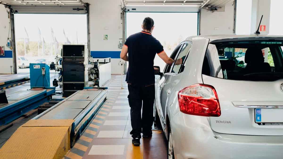 Técnico de ITV revisando un coche diésel antes de realizar la prueba de emisiones