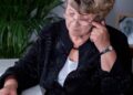 Mujer mayor con gafas revisando documentos de la Seguridad Social sobre su pensión de viudedad