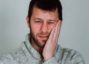 Hombre preocupado sosteniendo la mejilla, ilustrando la inquietud de perder el paro por infracciones del SEPE