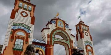 Portada de la Feria de Sevilla 2025 bajo nubes oscuras, anuncio de chubascos y frío según la AEMET