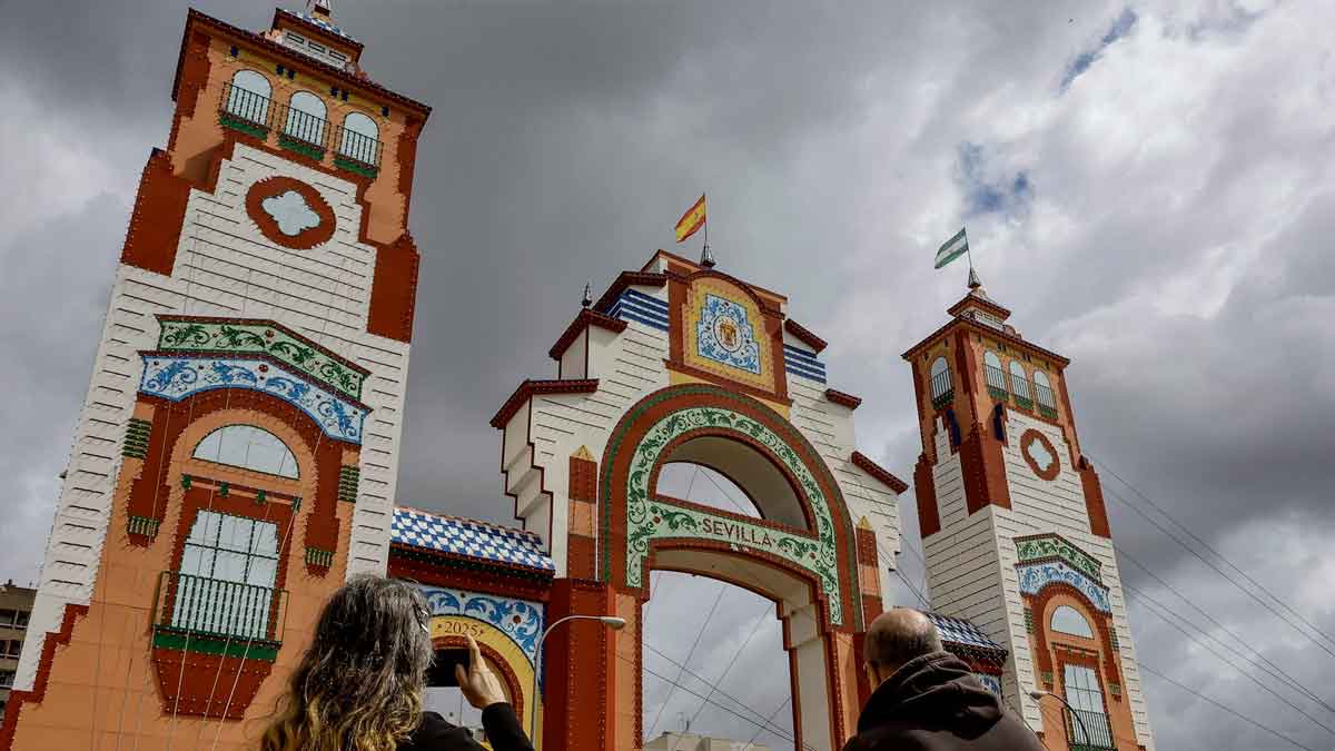 Portada de la Feria de Sevilla 2025 bajo nubes oscuras, anuncio de chubascos y frío según la AEMET