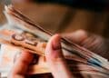 Persona contando billetes de 50 €, símbolo de compatibilizar salario parcial y subsidio del SEPE para un doble ingreso