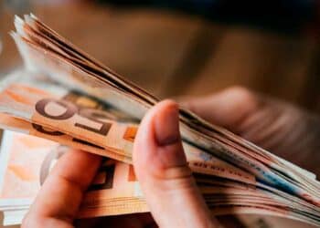 Persona contando billetes de 50 €, símbolo de compatibilizar salario parcial y subsidio del SEPE para un doble ingreso