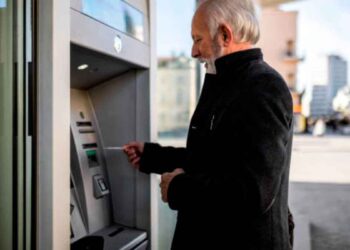 Hombre mayor retirando efectivo en un cajero automático tras recibir el adelanto del cobro de pensiones en mayo 2025