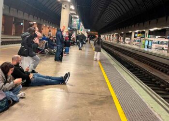 Pasajeros esperando en el andén por retraso de tren de Renfe en una estación ferroviaria en España