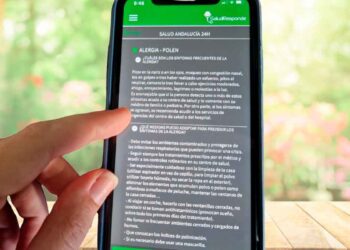 Dedos de una persona consultan los niveles de polen en la app gratuita Salud Responde desde su teléfono móvil