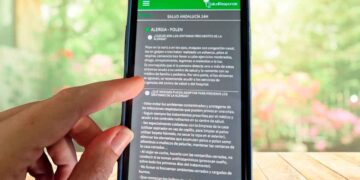 Dedos de una persona consultan los niveles de polen en la app gratuita Salud Responde desde su teléfono móvil
