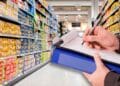 Inspector de Consumo revisando el etiquetado de alimentos en un pasillo de supermercado andaluz durante la campaña de control 2025