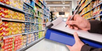 Inspector de Consumo revisando el etiquetado de alimentos en un pasillo de supermercado andaluz durante la campaña de control 2025