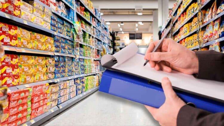 Inspector de Consumo revisando el etiquetado de alimentos en un pasillo de supermercado andaluz durante la campaña de control 2025