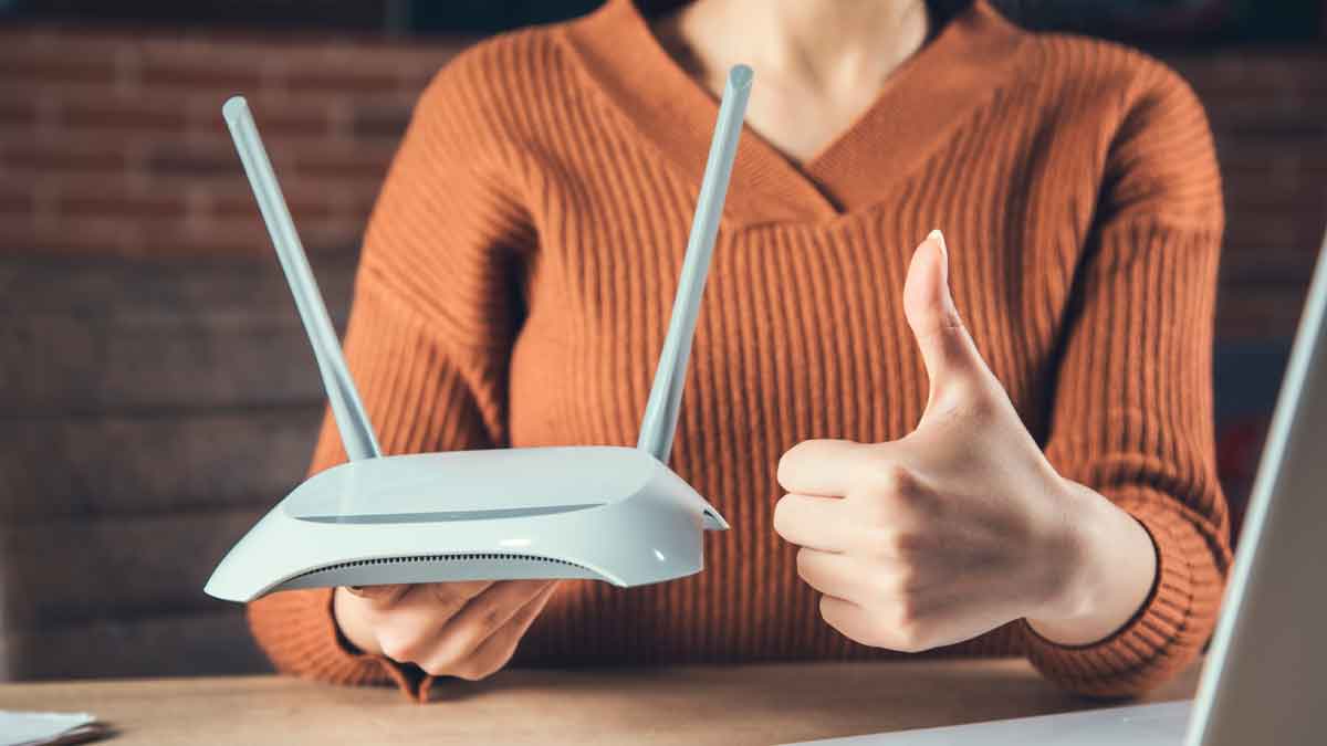 Mujer sostiene router y hace pulgar arriba, simbolizando la importancia de revisar contratos de telefonía e internet
