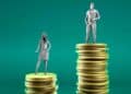 Ilustración de la brecha salarial en España 2025: mujer sobre una pila de monedas más baja y hombre sobre otra más alta, reflejando precariedad y desigualdad de género en el empleo