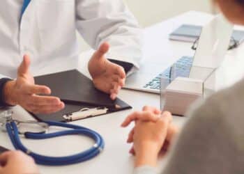 Médico explicando a un trabajador en baja médica cómo el despido afecta a su prestación por desempleo del SEPE
