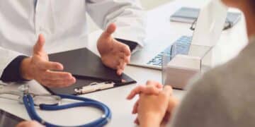 Médico explicando a un trabajador en baja médica cómo el despido afecta a su prestación por desempleo del SEPE