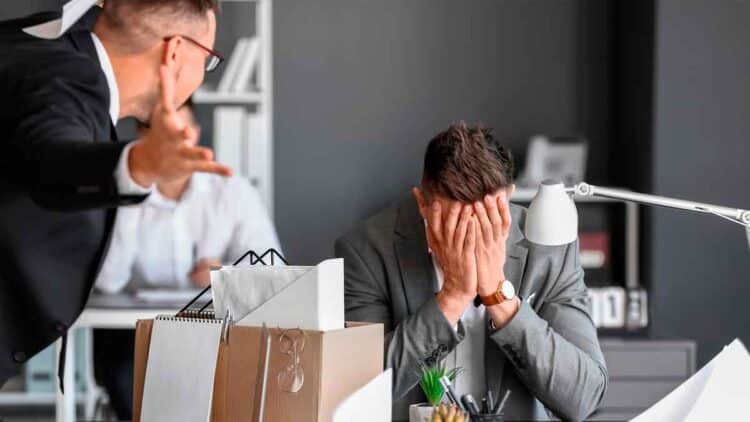 Empleado angustiado tras despido improcedente en una oficina en 2025