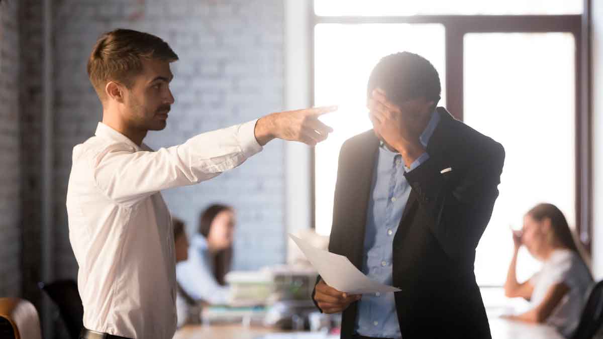 Jefe señalando la puerta a trabajador cabizbajo con carta en la mano, ejemplo de despido improcedente y posible reclamación de indemnización