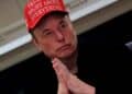 Elon Musk con gorra roja y manos entrelazadas advierte sobre una inminente crisis energética global causada por la demanda eléctrica