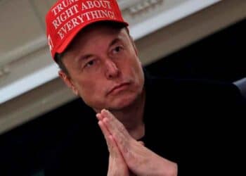Elon Musk con gorra roja y manos entrelazadas advierte sobre una inminente crisis energética global causada por la demanda eléctrica