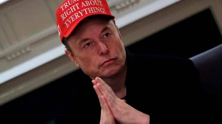 Elon Musk con gorra roja y manos entrelazadas advierte sobre una inminente crisis energética global causada por la demanda eléctrica
