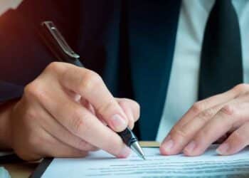 Mano de empresario firmando documento de reclamación de consumo