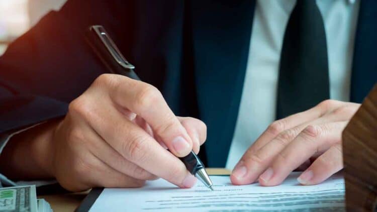 Mano de empresario firmando documento de reclamación de consumo