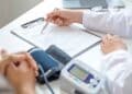 Médico revisando el informe de salud de un paciente durante una evaluación para incapacidad permanente