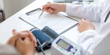 Médico revisando el informe de salud de un paciente durante una evaluación para incapacidad permanente