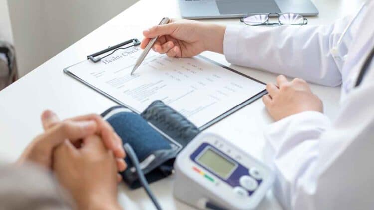 Médico revisando el informe de salud de un paciente durante una evaluación para incapacidad permanente