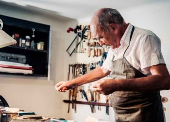 Hombre mayor trabajando en un taller artesanal, símbolo de los españoles que retrasan la jubilación más allá de los 65 años