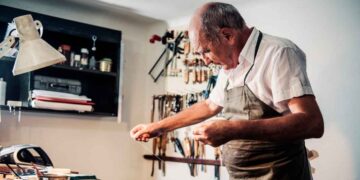 Hombre mayor trabajando en un taller artesanal, símbolo de los españoles que retrasan la jubilación más allá de los 65 años