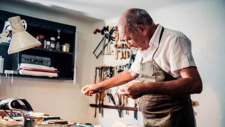 Hombre mayor trabajando en un taller artesanal, símbolo de los españoles que retrasan la jubilación más allá de los 65 años