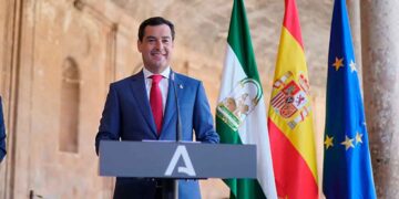 El presidente andaluz anuncia complemento de 187 euros para pensionistas frente a banderas de Andalucía, España y UE