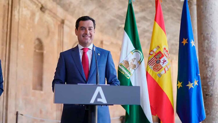 El presidente andaluz anuncia complemento de 187 euros para pensionistas frente a banderas de Andalucía, España y UE