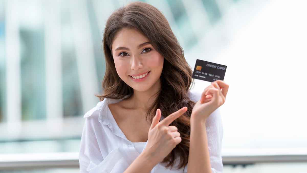Mujer joven sonriente mostrando una tarjeta de crédito sin cambiar de banco